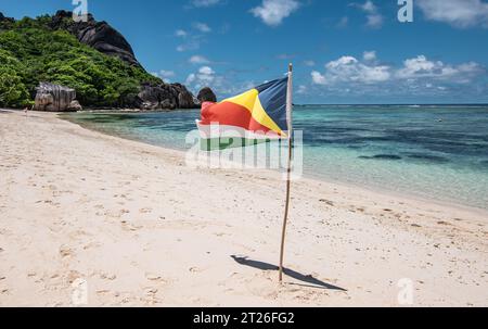 Drapeau des Seychelles sur la plage, l'île de la Digue. Banque D'Images