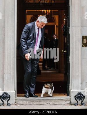 Londres, Royaume-Uni. 17 octobre 2023. Larry the Downing Street Cat tente d'entrer au n ° 10 alors que Steve Barclay, député, secrétaire d'État à la santé et à la protection sociale sort. Les politiciens du Parti conservateur britannique et les ministres du gouvernement Sunak assistent à la réunion hebdomadaire du cabinet au 10 Downing Street à Westminster. Crédit : Imageplotter/Alamy Live News Banque D'Images