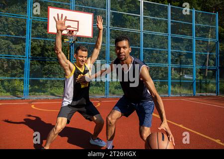 Joueurs de basket-ball de rue s'entraînant en plein air sur le court. Banque D'Images