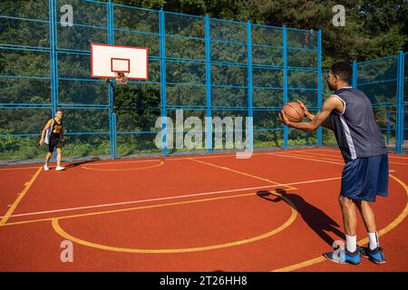 Joueurs de basket-ball de rue s'entraînant en plein air sur le court. Banque D'Images