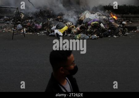 17 octobre 2023, Yogyakarta, région spéciale de Yogyakarta, Indonésie : un homme marche près des ordures brûlantes sur le bord de la route à Yogyakarta. (Image de crédit : © Angga Budhiyanto/ZUMA Press Wire) USAGE ÉDITORIAL SEULEMENT! Non destiné à UN USAGE commercial ! Banque D'Images