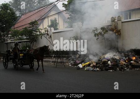 17 octobre 2023, Yogyakarta, région spéciale de Yogyakarta, Indonésie : une voiture passe près des ordures brûlantes sur le bord de la route à Yogyakarta. (Image de crédit : © Angga Budhiyanto/ZUMA Press Wire) USAGE ÉDITORIAL SEULEMENT! Non destiné à UN USAGE commercial ! Banque D'Images