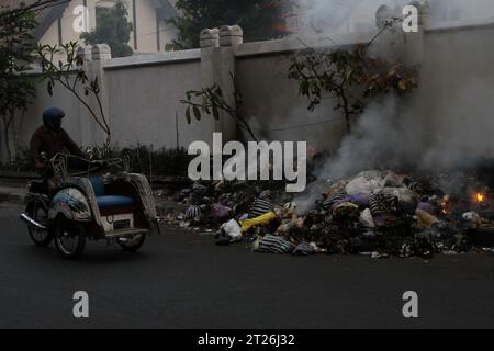 17 octobre 2023, Yogyakarta, région spéciale de Yogyakarta, Indonésie : un chauffeur de pédicule passe en brûlant des ordures sur le bord de la route à Yogyakarta. (Image de crédit : © Angga Budhiyanto/ZUMA Press Wire) USAGE ÉDITORIAL SEULEMENT! Non destiné à UN USAGE commercial ! Banque D'Images