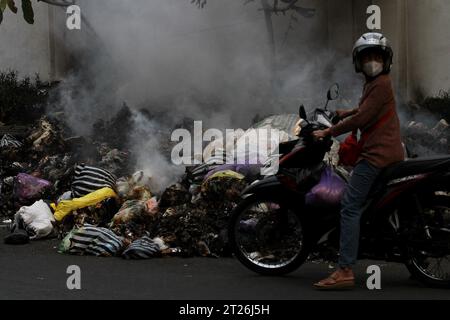 17 octobre 2023, Yogyakarta, région spéciale de Yogyakarta, Indonésie : un motocycliste est vu près de déchets brûlants sur le bord de la route à Yogyakarta. (Image de crédit : © Angga Budhiyanto/ZUMA Press Wire) USAGE ÉDITORIAL SEULEMENT! Non destiné à UN USAGE commercial ! Banque D'Images