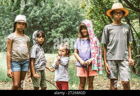 Petits explorateurs amoureux de la nature s'amusant ensemble pour une photo de groupe - groupe multiethnique d'écoliers heureux dans des vêtements décontractés explorant la nature et Banque D'Images