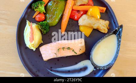 Délicieux steak de saumon frit avec pommes de terre rôties et légumes grillés Banque D'Images