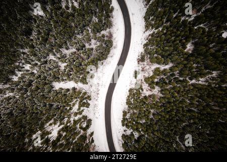 Forêt enneigée avec route serpentine dans les montagnes d'hiver. Vue de dessus. Photographie de paysage Banque D'Images
