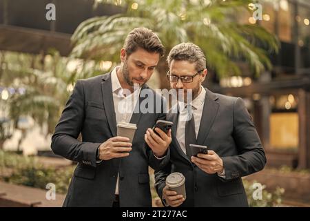 collègues professionnels avec rapports de stock par téléphone en combinaison. photo de collègues Banque D'Images
