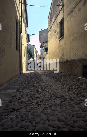 Ruelle pavée à l'ombre dans une ville italienne Banque D'Images