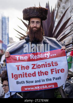 Un manifestant juif orthodoxe tient une bannière de protestation anti-sioniste lors de la marche pro-palestinienne dans le centre de Londres - 14/10/2023. Regarder la caméra. Banque D'Images