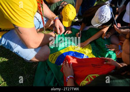 Pèlerins signant un drapeau brésilien en souvenir. Cérémonie d'ouverture des Journées mondiales de la Jeunesse 2023 à Lisbonne, Portugal. Banque D'Images
