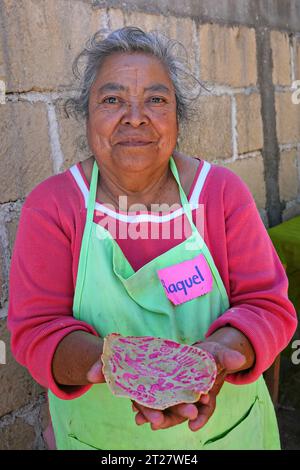 Une femme autochtone âgée Ottomi tient une tortillas Ceremoniales qu'elle a faite avec une presse spéciale et du jus de betterave pour la coloration à la coopérative de femmes El Salto Salud Indigena près de San Miguel de Allende, au Mexique. Banque D'Images
