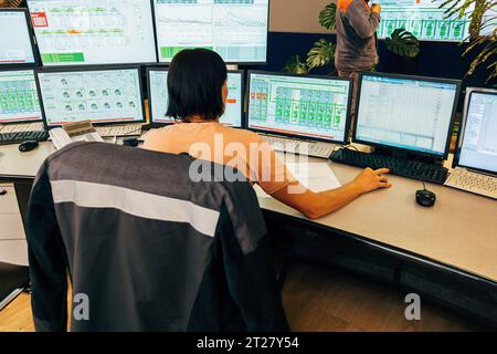 Opérateur travaillant dans la salle de contrôle de l'usine. Banque D'Images