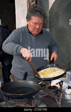 Homme cuisinant une omelette à la truffe sur la place aux herbes à Uzès, dans le sud de la France, lors de la foire annuelle à la truffe en janvier. Banque D'Images