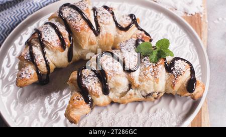 Croissants cuits au four avec confiture de fraises sur un comptoir de cuisine. Banque D'Images