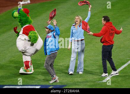 Philadelphie, États-Unis. 17 octobre 2023. Les acteurs de l'émission de télévision It's Always Sunny in Philadelphia Charlie Day, Rob McElhenney, Kaitlin Olson rejoint la mascotte des Phillies de Philadelphie, The Phillie Phanatic, pour encourager les Phillies lors du deuxième match de leur NLCS contre les Diamondbacks de l'Arizona au Citizens Bank Park à Philadelphie, le mardi 17 octobre 2023. Photo de Laurence Kesterson/UPI crédit : UPI/Alamy Live News Banque D'Images