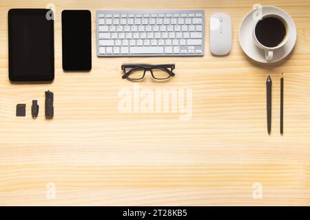 bureau en bois avec ordinateur portable, smartphone et autres fournitures de travail avec tasse de café. Vue de dessus avec espace de copie pour la saisie du texte. Espace de travail de conception o Banque D'Images
