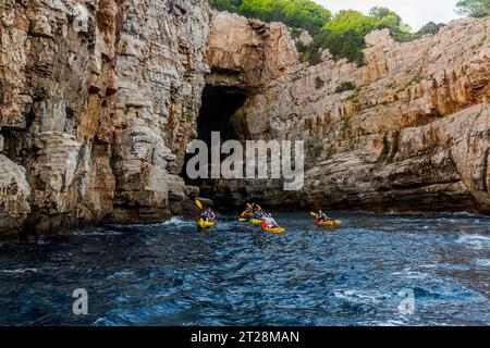 Kayakistes explorant les grottes de l'île de Lokrum en face de la vieille ville de Dubrovnik dans le sud de la Croatie. Banque D'Images