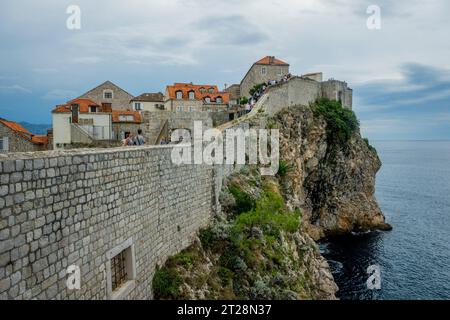 Les touristes sur le mur de la ville marchent autour de la vieille ville de Dubrovnik dans le sud de la Croatie. Banque D'Images