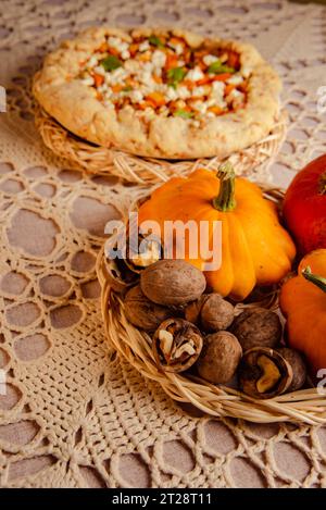 fête de la récolte avec citrouille crue et galette maison, tarte à la citrouille ouverte sur table Banque D'Images