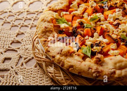 galette de citrouille maison, tarte ouverte sur nappe tricotée beige. automne nature morte confortable dans la cuisine Banque D'Images