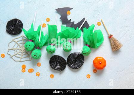 Composition avec sucettes savoureuses et décor Halloween sur fond clair Banque D'Images