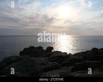 Coucher de soleil sur une falaise abrupte avec des rochers au large de LANd's End, Cornouailles, Angleterre Banque D'Images