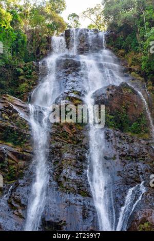Les eaux d'une chute d'eau coulant sur un grand rocher à travers la végétation de la forêt tropicale à Minas Gerais, Brésil Banque D'Images