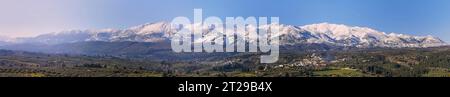 Super panorama shot, Lefka Ori en hiver, montagnes blanches, montagnes enneigées, village, champs verts, oliveraies. Ciel bleu sans nuages, Chania Banque D'Images