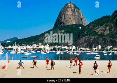 Les Brésiliens jouent au football sur la plage près de la montagne du pain de sucre, Rio de Janeiro, Brésil Banque D'Images