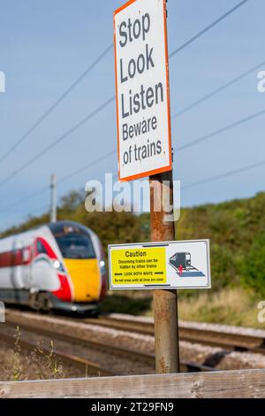 Attention, regardez dans les deux sens et Stop look Listern panneaux d'avertissement au passage à niveau sur la ligne principale de la côte est. Banque D'Images