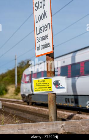 Attention, regardez dans les deux sens et Stop look Listern panneaux d'avertissement au passage à niveau sur la ligne principale de la côte est. Banque D'Images