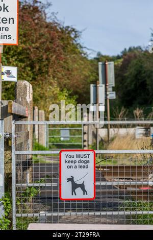 Vous devez garder les chiens sur une laisse, panneaux d'avertissement au passage à niveau sur la ligne principale de la côte est. Banque D'Images