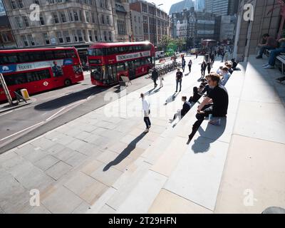 Bishopsgate, au centre de Londres, le 10 octobre 2023, alors que les employés de bureau et les navetteurs profitent du soleil d'automne exceptionnellement chaud. Des piétons et une ligne de bus à impériale rouges circulent sur l'artère principale, qui sert d'artère principale entre la gare de Liverpool Street et le quartier financier de la Cité de Londres Banque D'Images