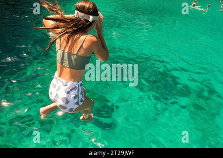 Fille plongeant dans la mer profitant des vacances d'été dans l'île de Zakynthos en Grèce. Banque D'Images