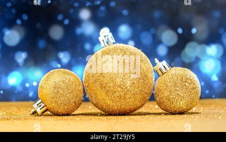 Boules de Noël dorées et fond de Noël bleu. Banque D'Images