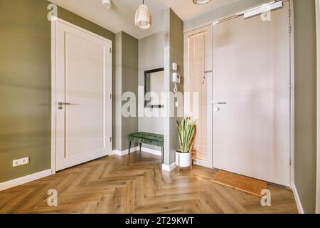 Intérieur de la chambre avec miroir et table par porte ouverte menant au salon à l'appartement contemporain Banque D'Images