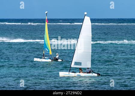 Voiliers catamaran Hobie Cat naviguant dans la mer des Caraïbes à San Pedro sur Ambergris Caye au Belize. Le saut de vague à la barrière de corail de Belize est vis Banque D'Images