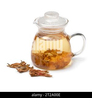 Théière en verre avec des feuilles d'hibiscus blanches et un tas de feuilles séchées à l'avant isolé sur fond blanc en gros plan Banque D'Images