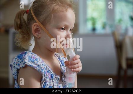 petite fille dans un masque pour les inhalations, faisant l'inhalation avec  nébuliseur à la maison inhalateur sur la table, intérieur, enfant malade  16264944 Photo de stock chez Vecteezy