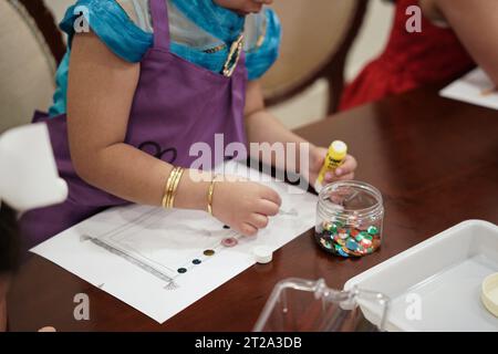 artisanat pour enfants. enfants coloriant une décoration d'un papier. Banque D'Images