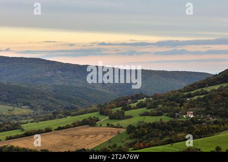 Paysage d'automne rural au coucher du soleil. Vue d'en haut dans la vallée. Avec champ, forêt et collines. Maisons solitaires . Ciel coloré. Horna Suca, Slovaquie. Banque D'Images