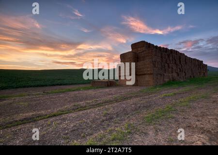 Paysage rural de soirée d'automne avec des balles de champ et de paille au coucher du soleil. Beau ciel bleu avec des nuages oranges.. Zone agricole Chocholna, Slovaquie Banque D'Images