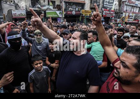 Naplouse, Territoires palestiniens. 18 octobre 2023. Des manifestants palestiniens font des gestes et chantent des slogans lors d’une manifestation contre Israël dans la ville de Naplouse, en Cisjordanie, à la suite d’une explosion dévastatrice à l’hôpital Ahli Arab dans la bande de Gaza qui a tué des centaines de personnes. Crédit : Ayman Nobani/dpa/Alamy Live News Banque D'Images