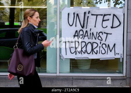 Bruxelles, Belgique. 18 octobre 2023. Des gens marchent devant l'entrée d'un bâtiment où deux ressortissants suédois ont été tués lors d'une attaque à Bruxelles, Belgique le 18 octobre 2023 Credit : ALEXANDROS MICHAILIDIS/Alamy Live News Banque D'Images