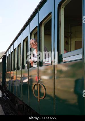 Passager regardant par la fenêtre du train historique du Douro circulant entre Régua et Tua en suivant le fleuve Douro, Portugal, Europe Banque D'Images
