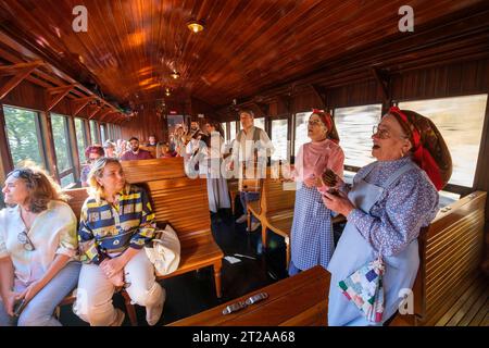 Les gens en vêtements traditionnels chantent à l'intérieur du train historique du Douro qui circule entre Régua et Tua en suivant le fleuve Douro, Portugal, Europe Banque D'Images