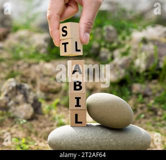 Une pile de cubes en bois forme les mots allemands 'labil' (instable) et 'stabil' (stable). Banque D'Images