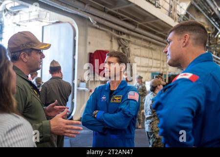 L'équipage d'Artemis II visite la base navale de San Diego. Navire amphibie de transport à quai USS John P. Murtha (LPD 26) le capitaine Doug Langenberg, commandant, à gauche, explique à l’astronaute de la NASA, le capitaine Reid Wiseman, et à l’astronaute de l’Agence spatiale canadienne Jeremy Hansen, à droite, les capacités de récupération du navire, le 19 juillet 2023. En préparation de la mission Artemis II de la NASA, qui enverra quatre astronautes à Orion au-delà de la Lune, la NASA et la marine américaine effectueront une série de tests pour démontrer et évaluer les processus, les procédures et le matériel utilisés dans les opérations de récupération pour la mission lunaire avec équipage Banque D'Images