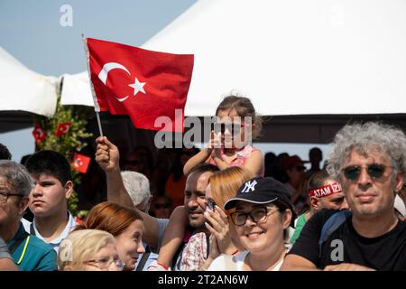 Izmir, Turquie, le 9 septembre 2023 : un moment réconfortant capturant une fillette de 8 à 9 ans avec des lunettes de soleil, perchée sur les épaules de son père, agitant le Banque D'Images